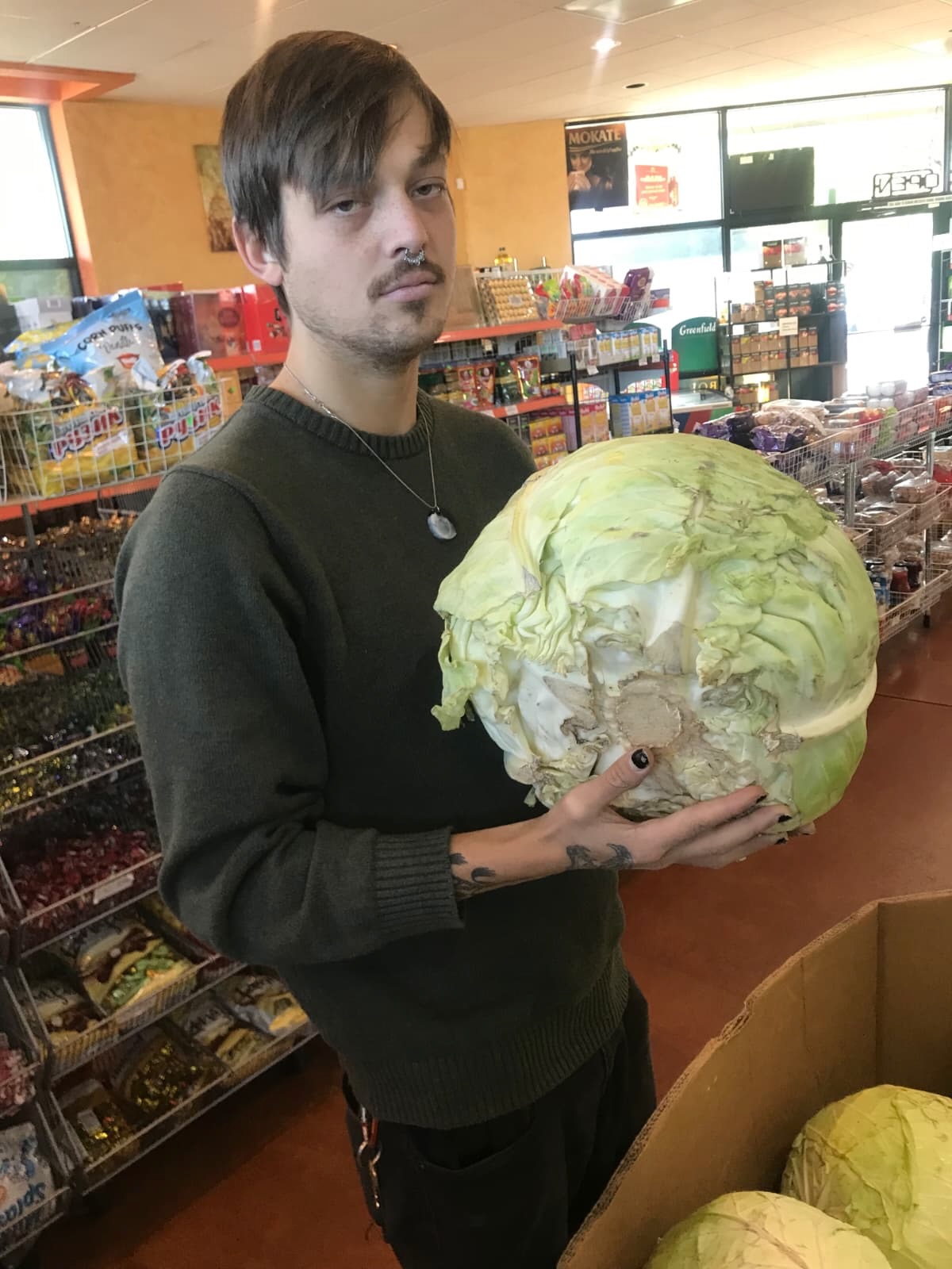 A man holding a large cabbage.