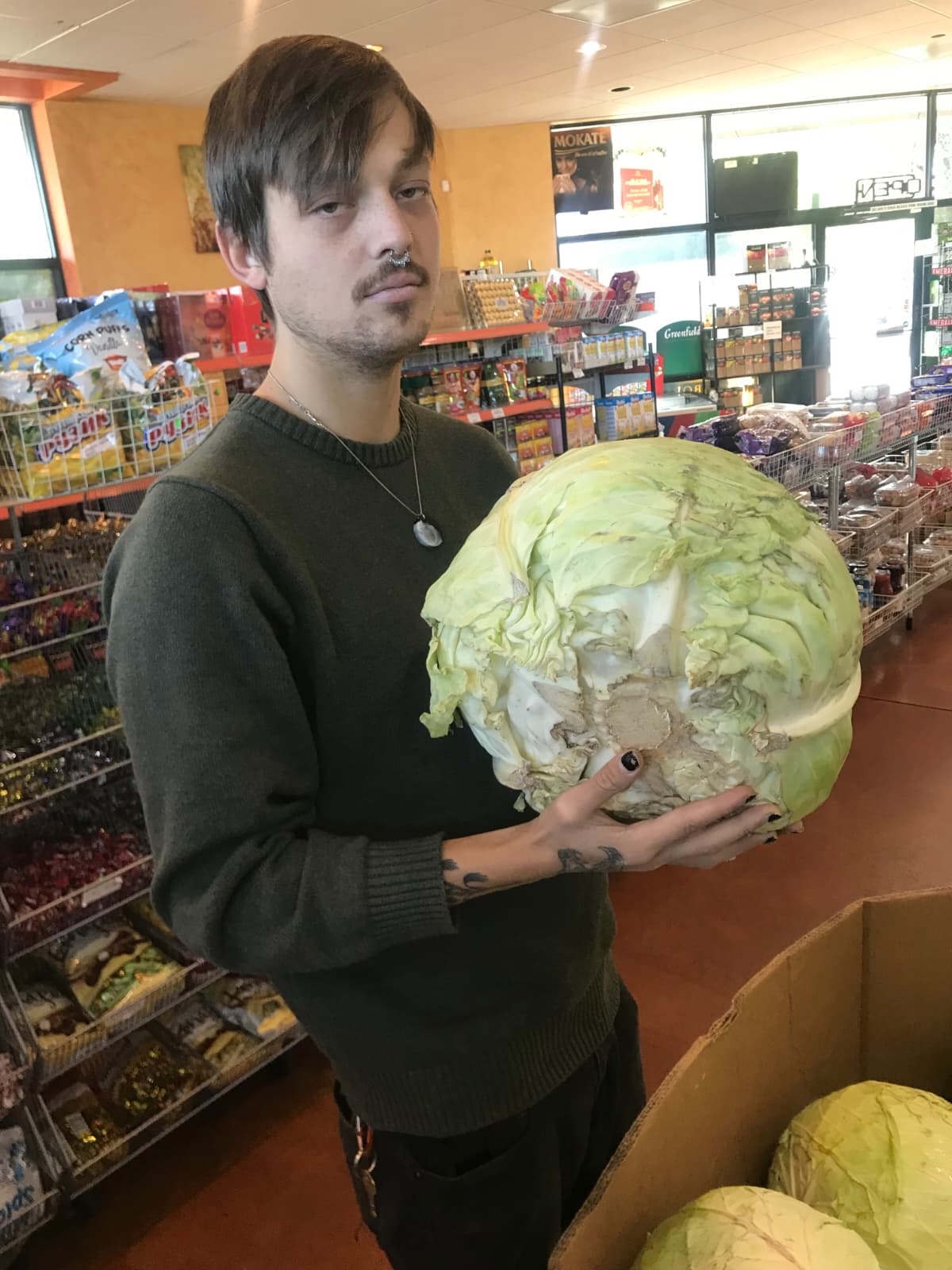 A man holding a large cabbage.